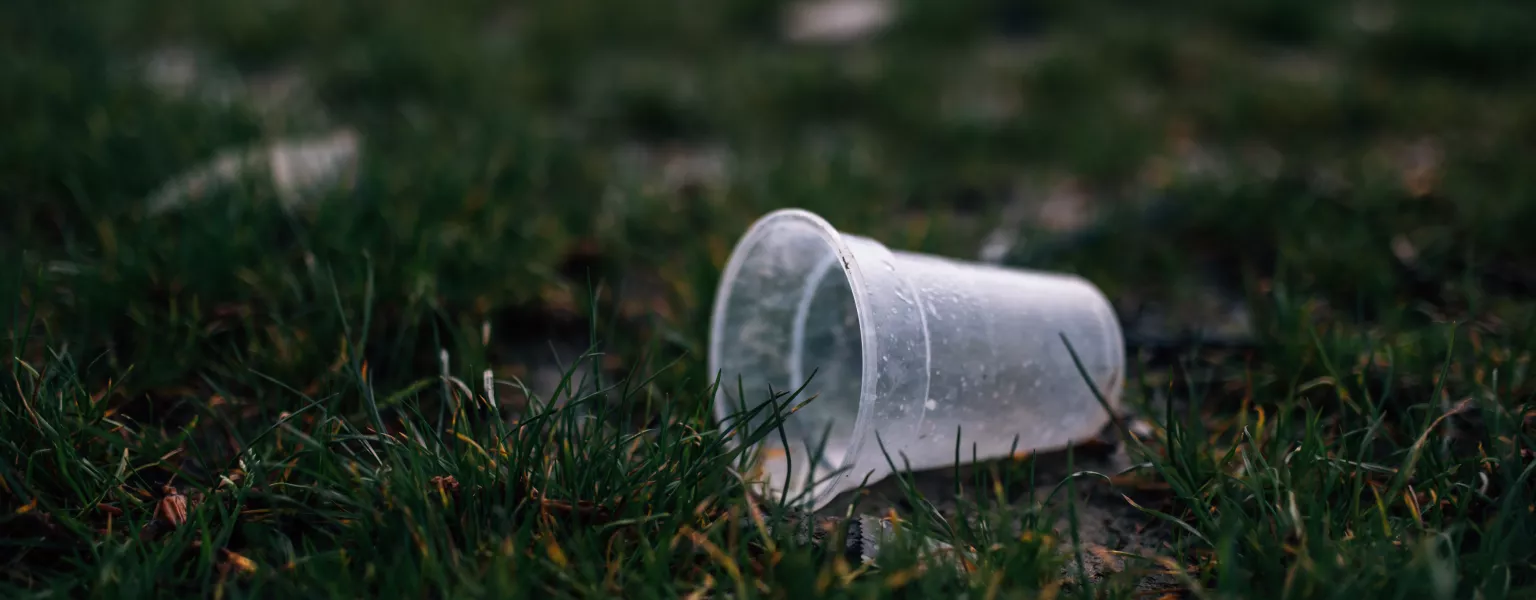 Close up of a clear plastic cup thrown in grass credit Ivan Radic